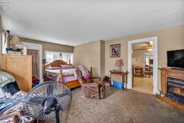 carpeted bedroom with a glass covered fireplace