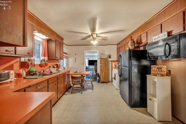 kitchen featuring brown cabinetry, a ceiling fan, black appliances, light countertops, and a sink