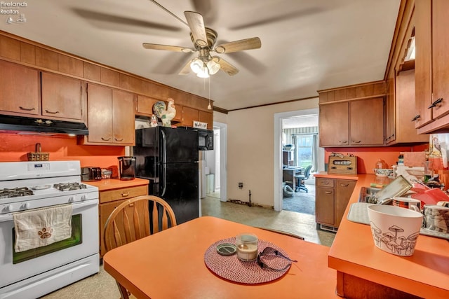 kitchen with light countertops, freestanding refrigerator, white range with gas stovetop, under cabinet range hood, and ceiling fan