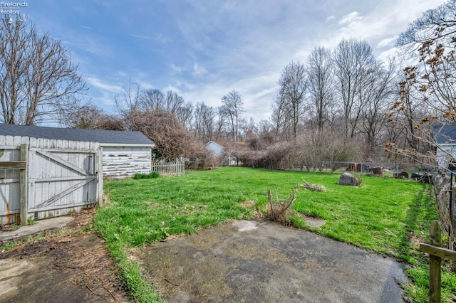 view of yard with a patio area, fence, and an outdoor structure