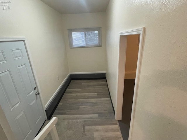 hallway featuring baseboards and wood finished floors