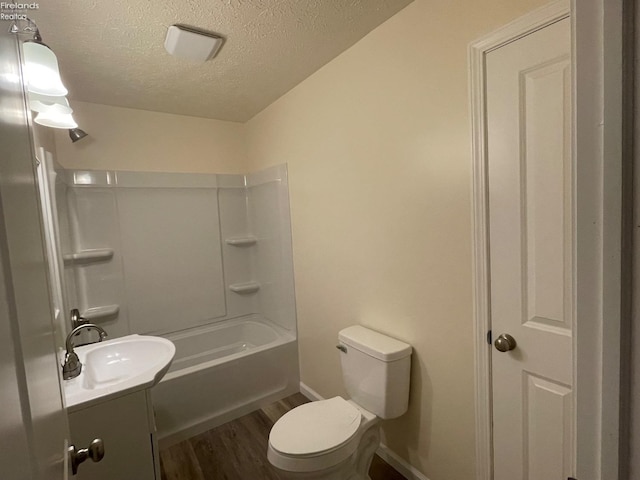 bathroom with vanity, baseboards, a textured ceiling, toilet, and wood finished floors