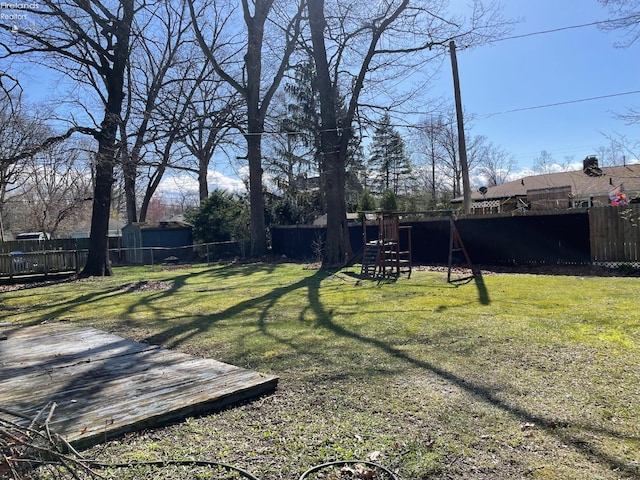 view of yard with a fenced backyard and a playground