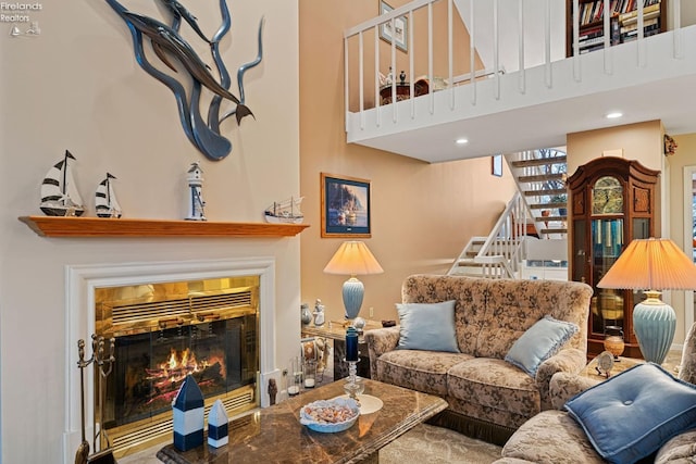 526 Mariner Vlg, Huron, OH 44839 - living area with a tiled fireplace, a towering ceiling, and stairs