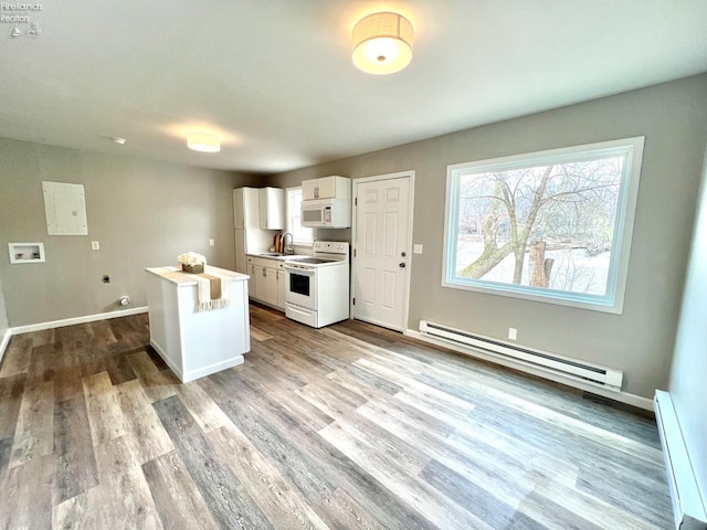 kitchen featuring baseboard heating, white appliances, white cabinetry, a baseboard radiator, and wood finished floors