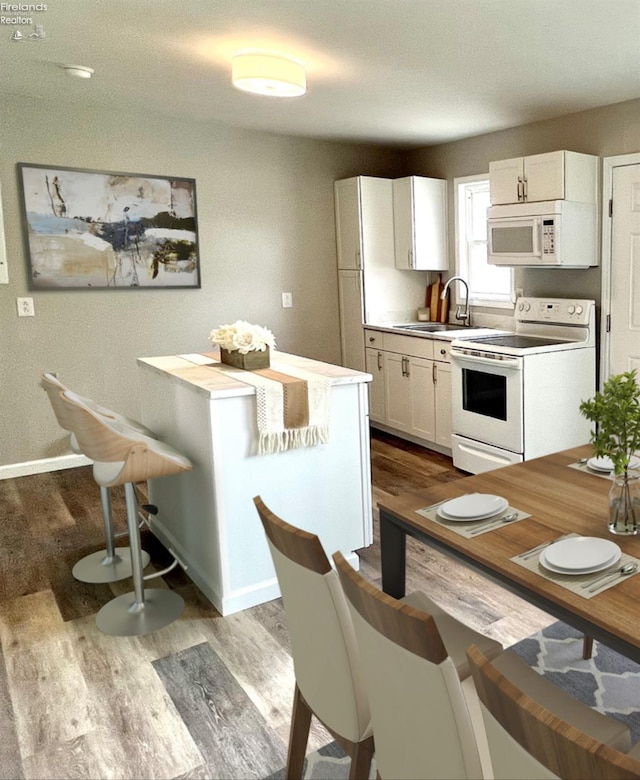 kitchen featuring a sink, white cabinetry, white appliances, and dark wood-style floors