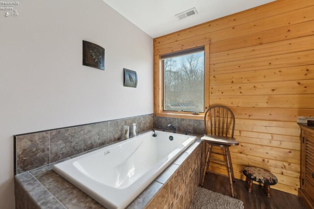 3769 Prospect Rd, New London, OH 44851 - full bath with wooden walls, visible vents, a bath, and wood finished floors