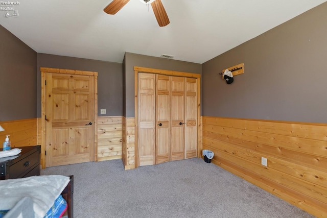 3769 Prospect Rd, New London, OH 44851 - carpeted bedroom featuring wood walls, visible vents, and a wainscoted wall