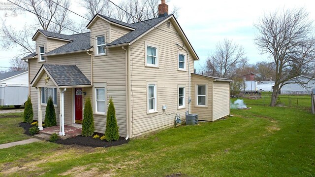 3510 Ohio St, Sandusky, OH 44870 - exterior space featuring a shingled roof, a lawn, a chimney, fence, and central air condition unit