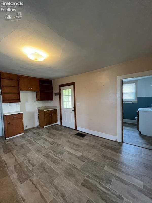 unfurnished living room with visible vents and baseboards