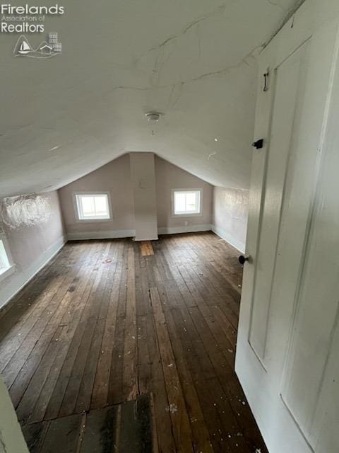 additional living space with baseboards, vaulted ceiling, and hardwood / wood-style floors
