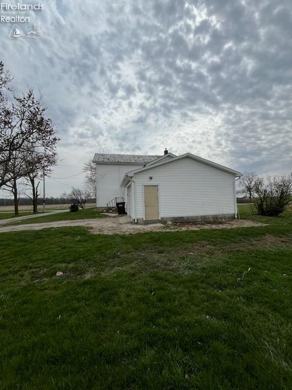 view of home's exterior with a yard and entry steps