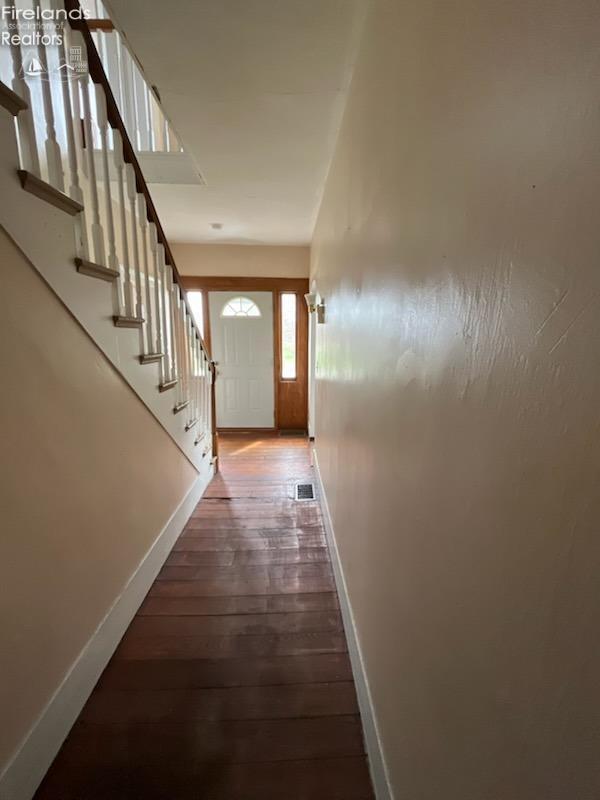 entryway featuring stairs, visible vents, baseboards, and hardwood / wood-style floors