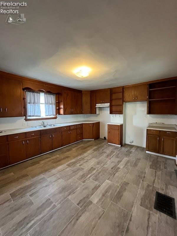 kitchen featuring brown cabinets, visible vents, and open shelves