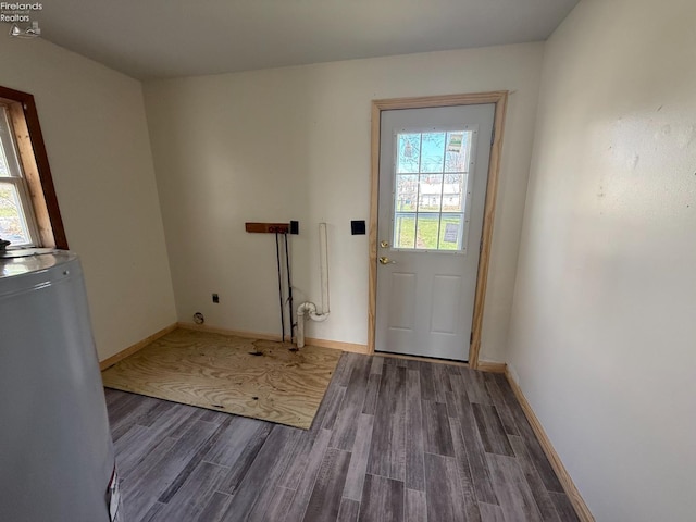 doorway to outside with water heater, dark wood-style floors, and baseboards