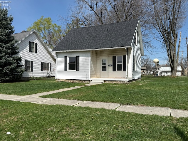 cape cod-style house with a front lawn and a shingled roof