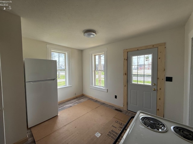 doorway featuring visible vents, baseboards, and light wood-type flooring