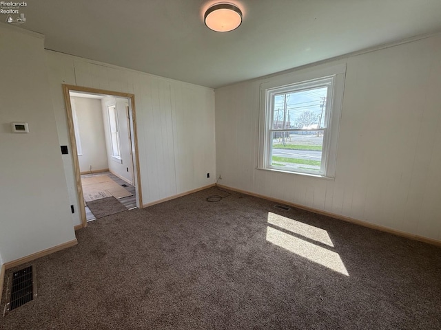 carpeted empty room featuring visible vents and baseboards
