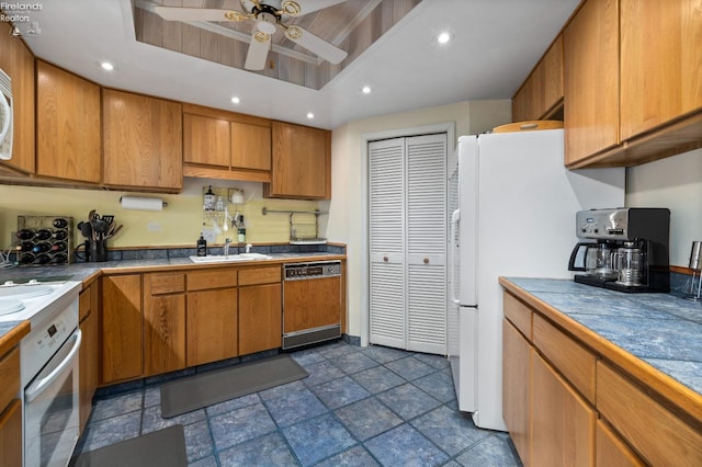 kitchen featuring recessed lighting, a sink, white appliances, brown cabinetry, and ceiling fan