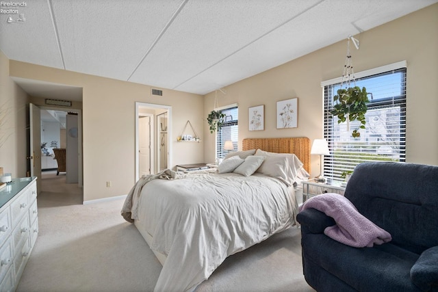 bedroom featuring visible vents, carpet flooring, and a textured ceiling