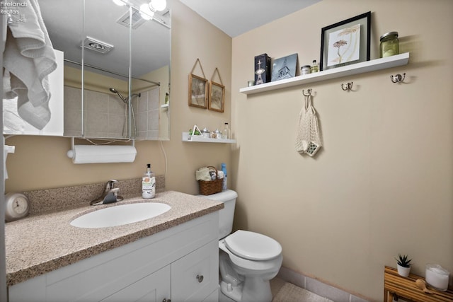 bathroom featuring toilet, walk in shower, vanity, and visible vents