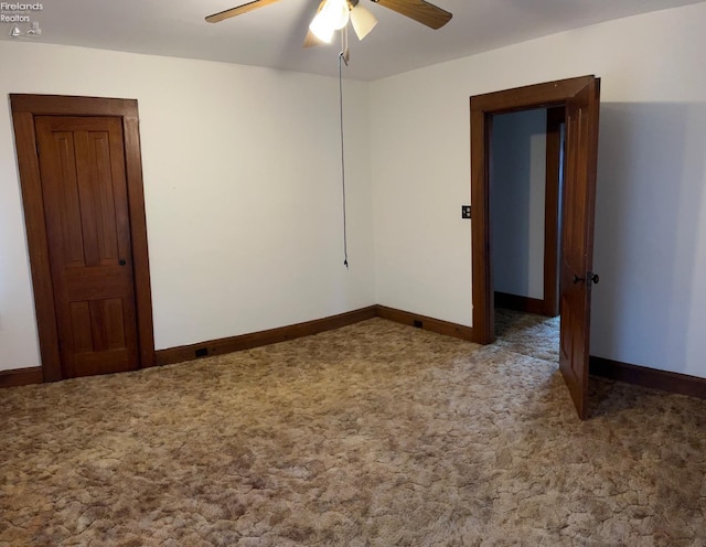empty room featuring carpet, baseboards, and a ceiling fan