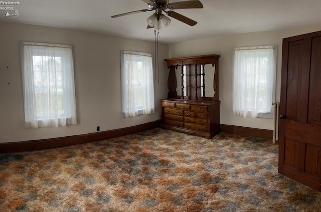 unfurnished bedroom featuring multiple windows, baseboards, and carpet floors