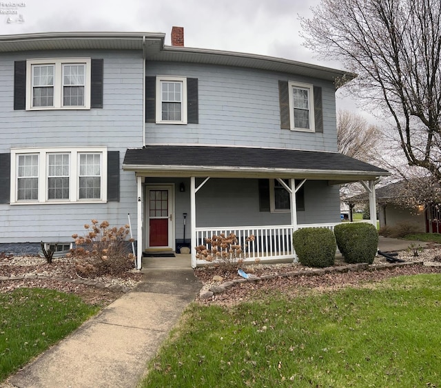 traditional-style house featuring covered porch and a chimney