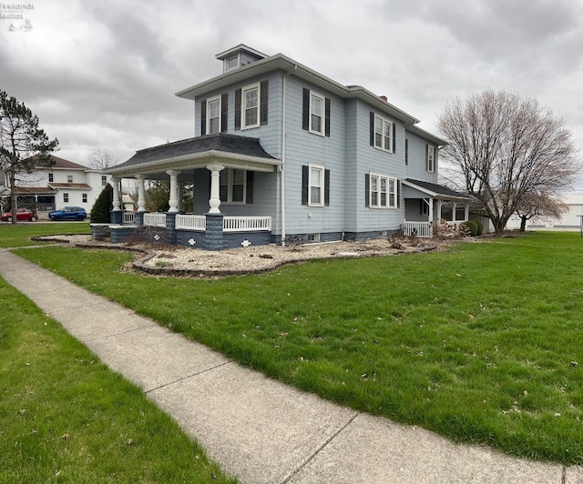 rear view of house featuring covered porch and a lawn