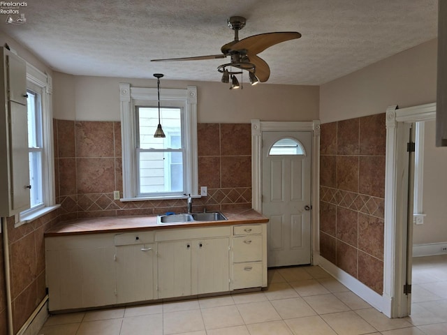 430 Perry St, Sandusky, OH 44870 - kitchen with a textured ceiling, ceiling fan, a sink, and light tile patterned floors