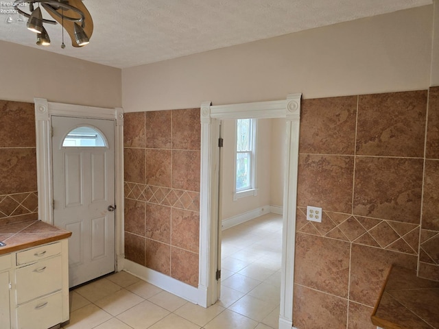 430 Perry St, Sandusky, OH 44870 - foyer with a textured ceiling, light tile patterned floors, and tile walls