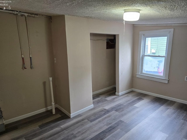 430 Perry St, Sandusky, OH 44870 - unfurnished bedroom with a closet, baseboards, wood finished floors, and a textured ceiling