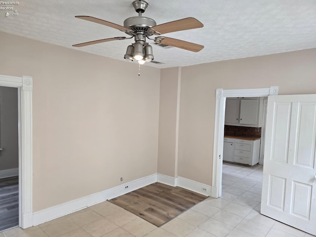 430 Perry St, Sandusky, OH 44870 - empty room with a textured ceiling, ceiling fan, baseboards, and light tile patterned floors