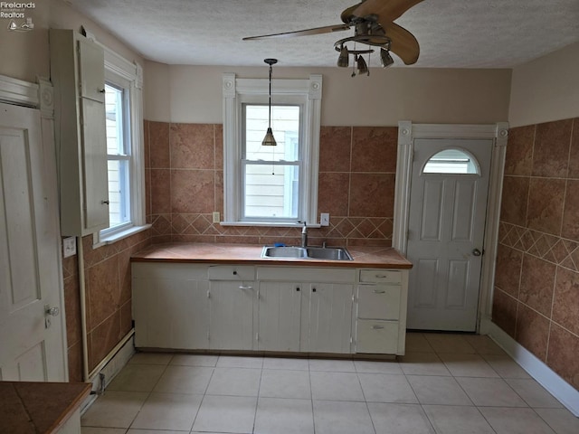 430 Perry St, Sandusky, OH 44870 - kitchen with a sink, tile walls, ceiling fan, baseboard heating, and light tile patterned flooring