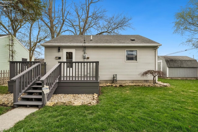 rear view of property featuring a yard, an outdoor structure, a storage unit, a shingled roof, and a deck