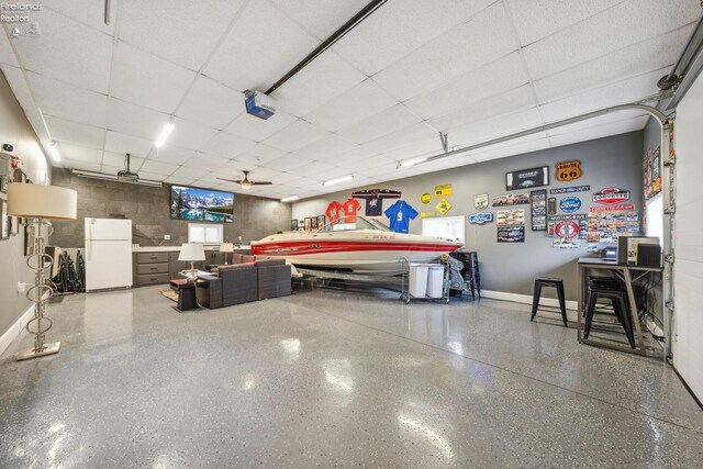 garage with baseboards and freestanding refrigerator