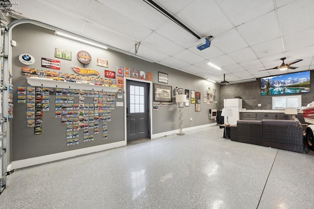 garage with baseboards, ceiling fan, and a garage door opener