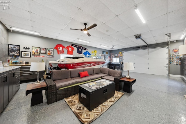 living room with speckled floor, ceiling fan, and a drop ceiling