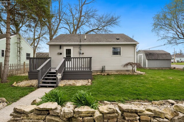 rear view of house featuring an outdoor structure, a shed, a yard, a deck, and fence