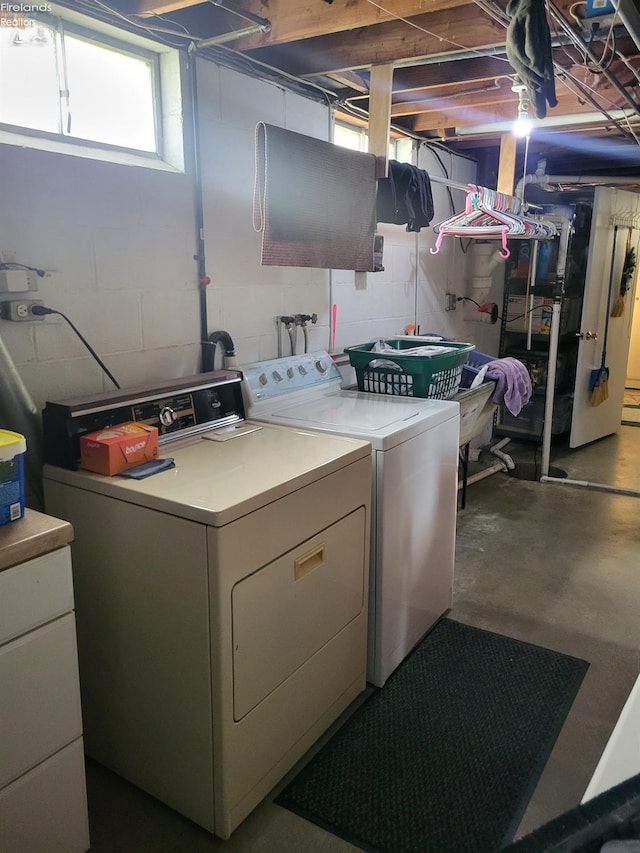 washroom featuring independent washer and dryer, laundry area, and concrete block wall