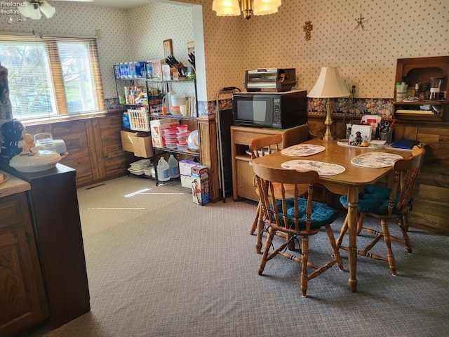 carpeted dining room with wallpapered walls