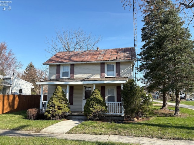 traditional home with a porch, a front lawn, and fence