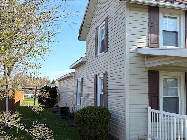 view of side of home with central AC unit and fence
