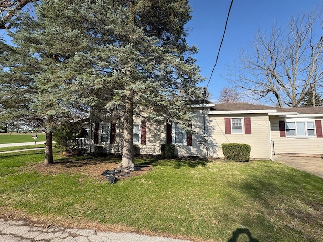 view of property hidden behind natural elements featuring a front lawn