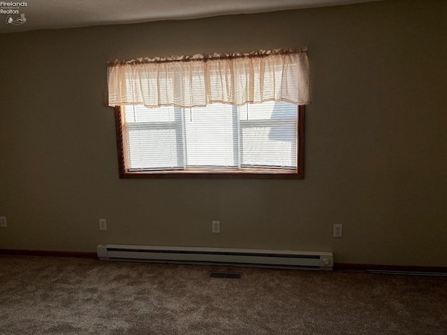 carpeted spare room featuring a baseboard radiator, plenty of natural light, visible vents, and baseboards