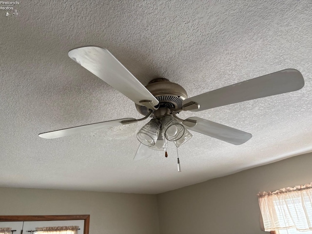 details featuring ceiling fan and a textured ceiling