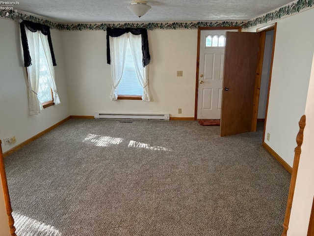 spare room with a baseboard heating unit, baseboards, and carpet