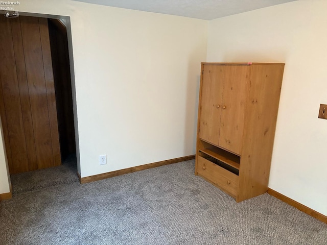 empty room with baseboards and carpet flooring