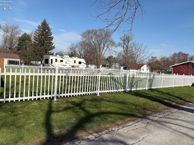 view of gate with a yard and a fenced front yard