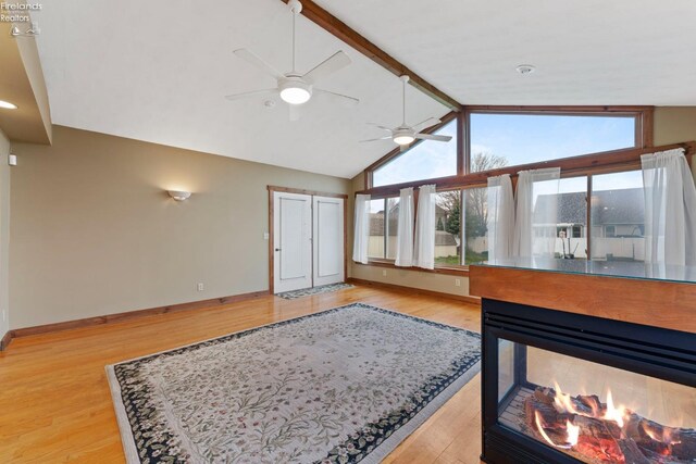 1001 Birchwood Dr, Sandusky, OH 44870 - living room featuring lofted ceiling with beams, baseboards, a ceiling fan, and light wood-style flooring